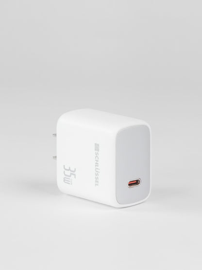 A standalone white Schlüssel 35W GaN wall charger block with a silver front faceplate and a single USB-C port, captured from a three-quarter perspective on a light gray background