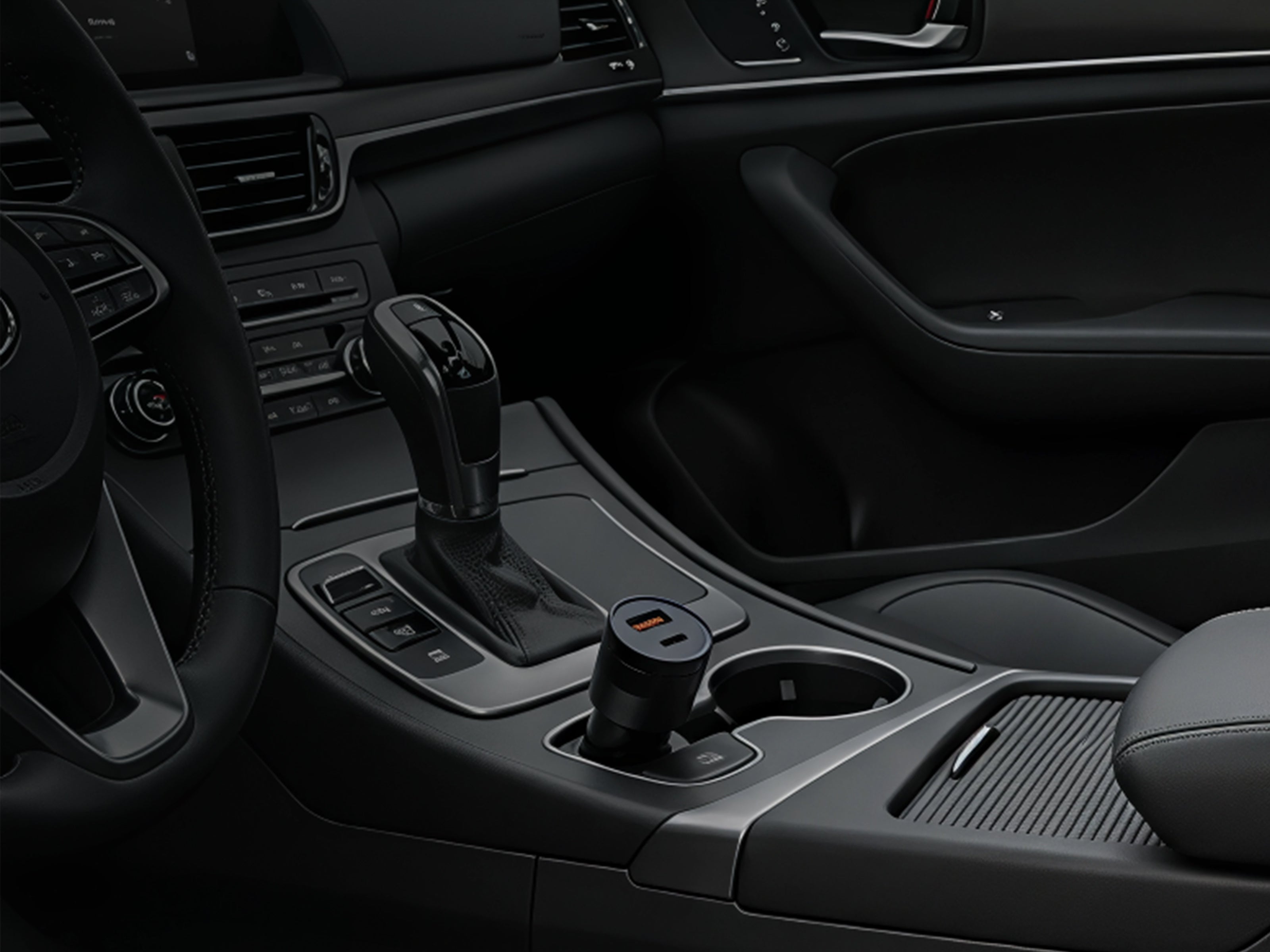 Schlussel black car USB charger plugged into the center console power outlet of a modern vehicle interior.