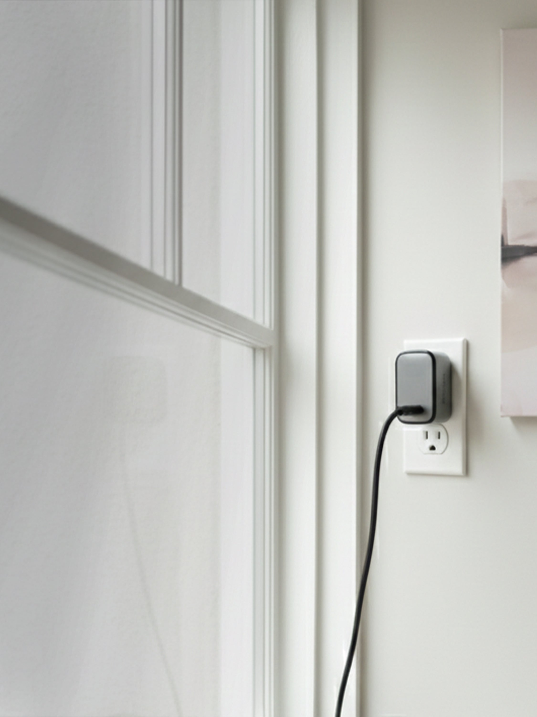 Schlüssel compact wall charger connected to a power outlet in a modern interior