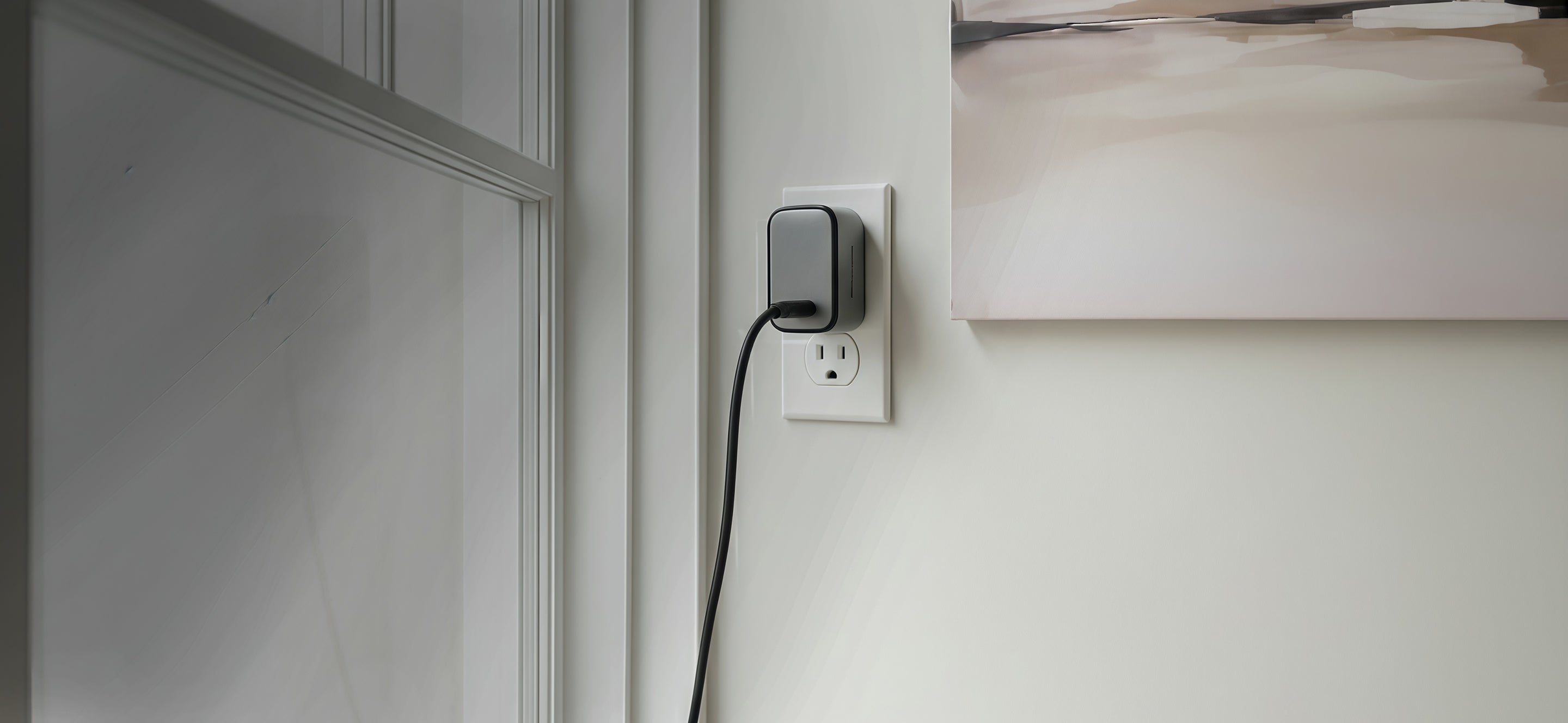 Schlüssel compact wall charger connected to a power outlet in a modern interior