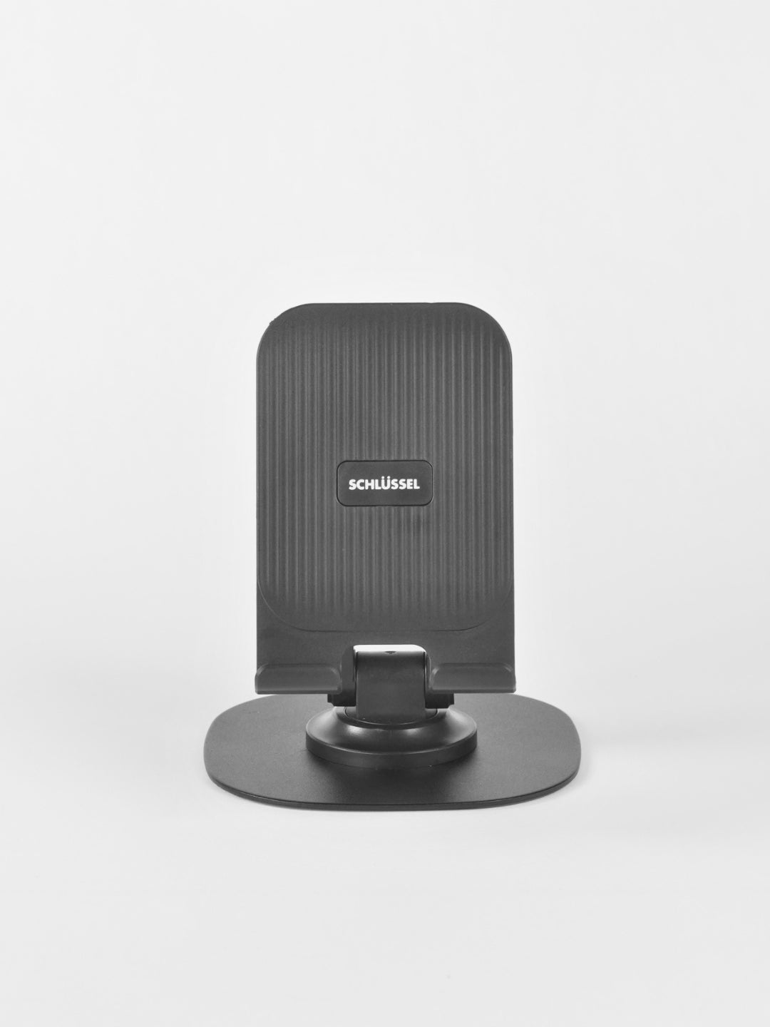 Straight-on front view of the black Schlüssel adjustable desktop phone stand, displaying its vertically ridged backrest, central brand logo, and sturdy base plate against a light gray background