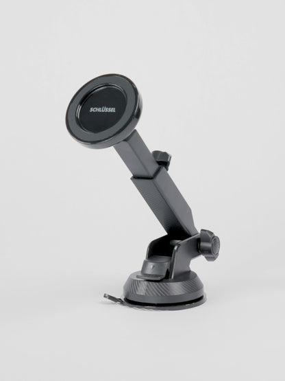 Black Schlüssel magnetic car phone holder showing its front circular magnetic face, telescopic arm, and dual adjustment knobs, positioned on a seamless light gray background